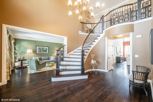 foyer entrance featuring a high ceiling, a notable chandelier, and dark hardwood / wood-style floors