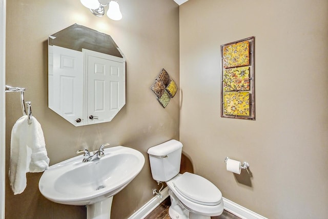 bathroom with toilet, hardwood / wood-style floors, and sink