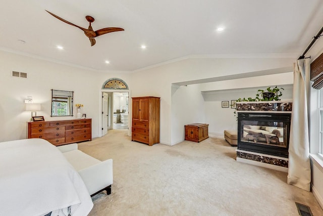 carpeted bedroom featuring ceiling fan, crown molding, vaulted ceiling, and multiple windows