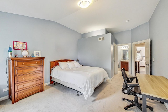 bedroom with lofted ceiling, ensuite bath, and light colored carpet