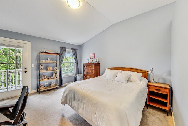 carpeted bedroom with lofted ceiling and access to exterior