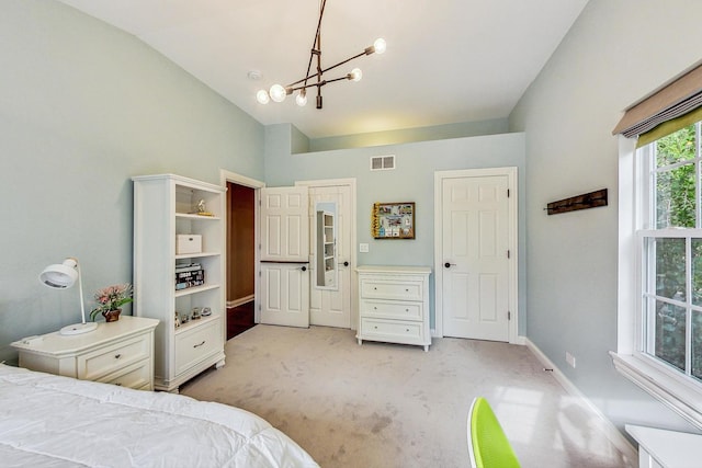 bedroom with an inviting chandelier, lofted ceiling, and light carpet