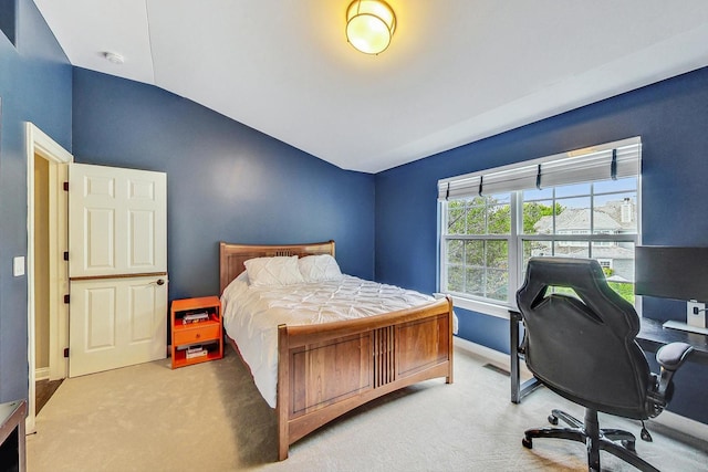 carpeted bedroom with lofted ceiling