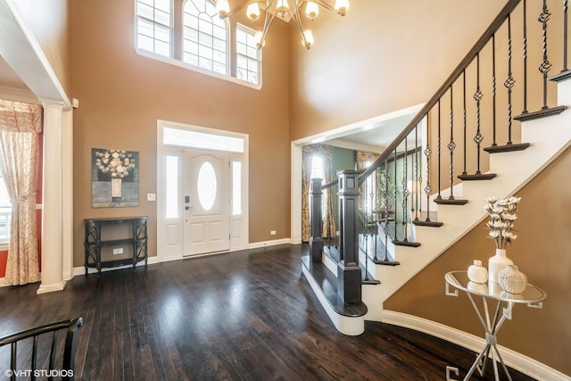 foyer entrance with a towering ceiling, hardwood / wood-style floors, and a healthy amount of sunlight