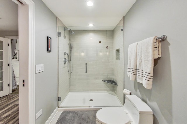 bathroom featuring toilet, an enclosed shower, and hardwood / wood-style floors