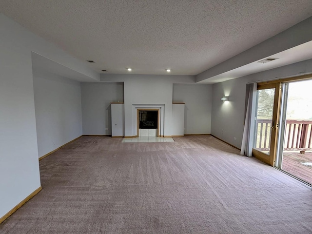 unfurnished living room with light colored carpet and a textured ceiling