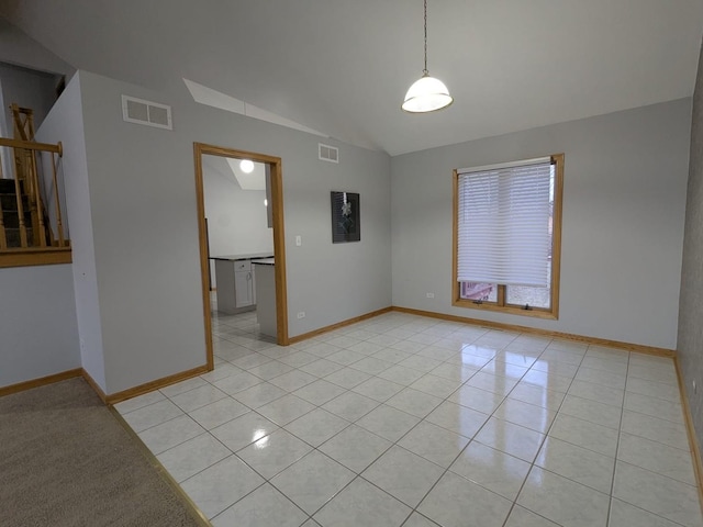 tiled empty room with vaulted ceiling