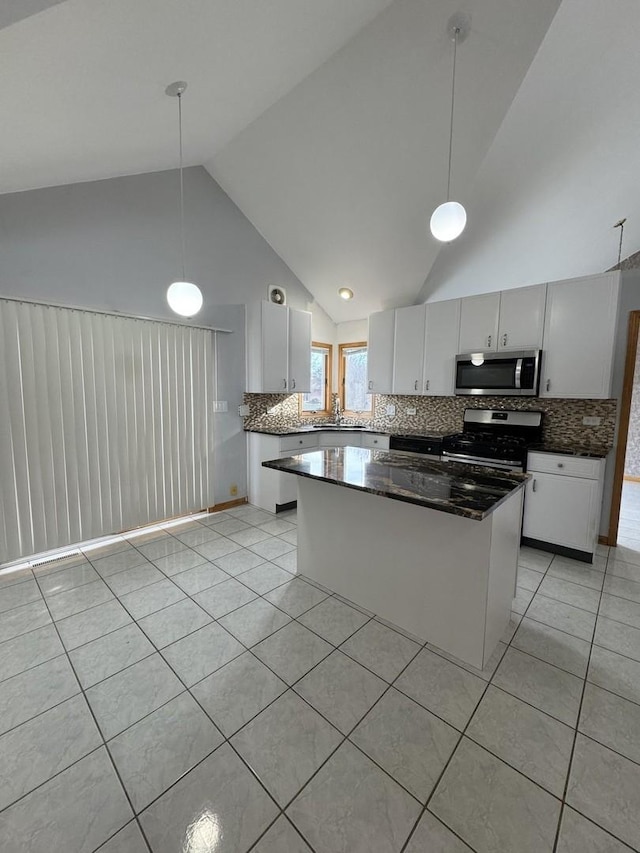 kitchen with tasteful backsplash, white cabinetry, stainless steel appliances, and decorative light fixtures