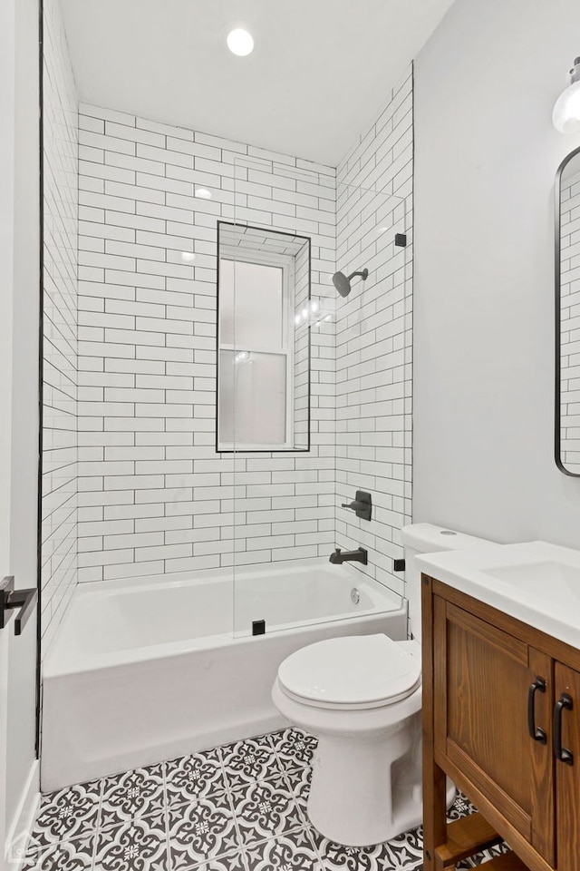 full bathroom with tiled shower / bath combo, vanity, tile patterned floors, and toilet