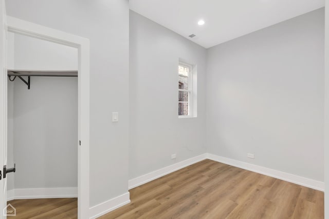 unfurnished bedroom featuring a closet and light hardwood / wood-style flooring