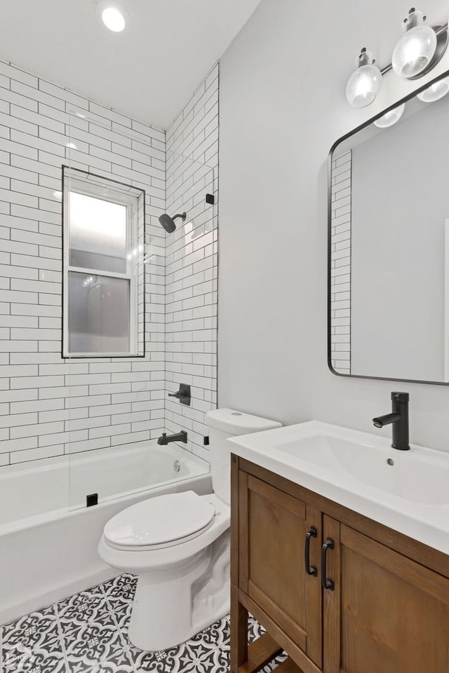 full bathroom featuring tiled shower / bath, vanity, tile patterned floors, and toilet