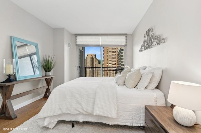 bedroom featuring access to exterior and dark wood-type flooring