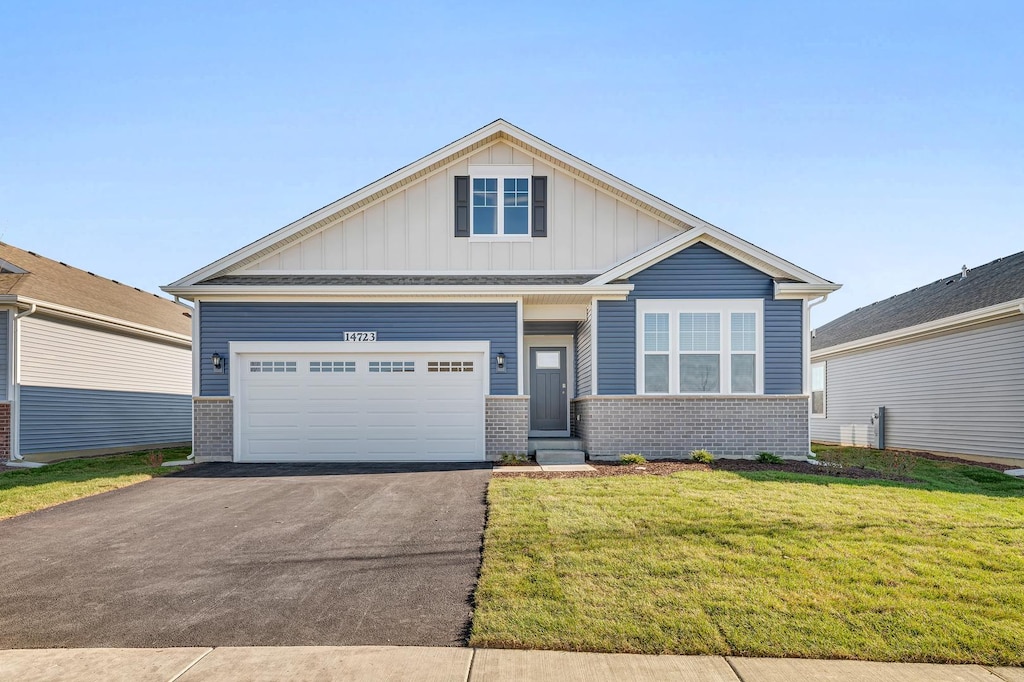 view of front of home with a front yard and a garage