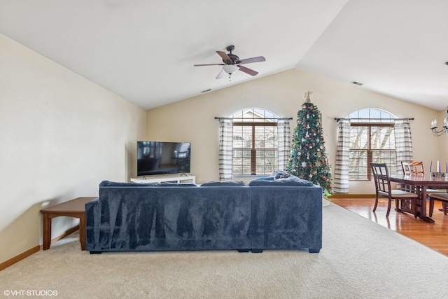 carpeted living room with vaulted ceiling, plenty of natural light, and ceiling fan