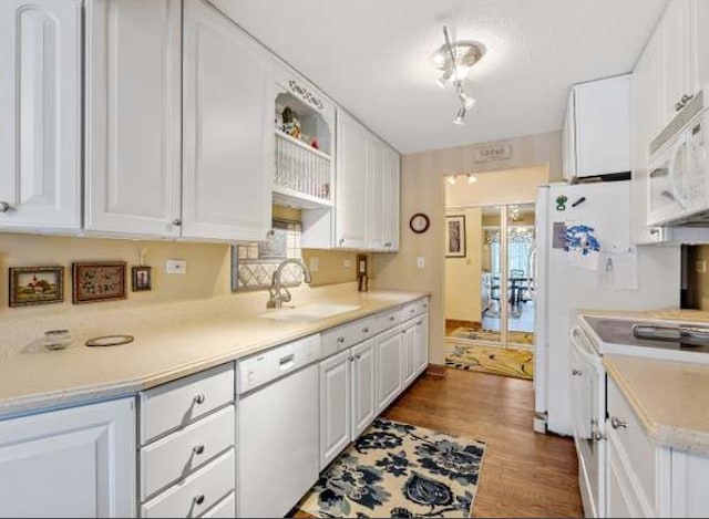 kitchen featuring white cabinets, wood-type flooring, white appliances, and sink