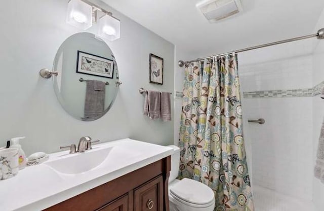 bathroom featuring toilet, vanity, and walk in shower