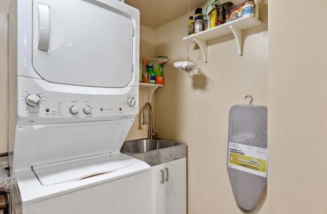 clothes washing area featuring sink and stacked washer / dryer