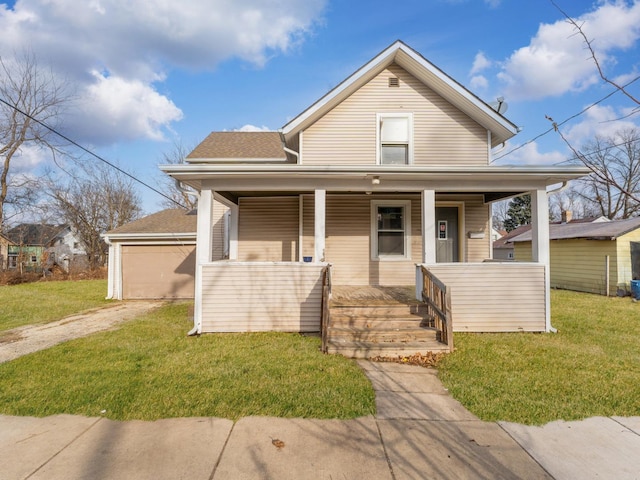 bungalow featuring covered porch, a garage, and a front lawn