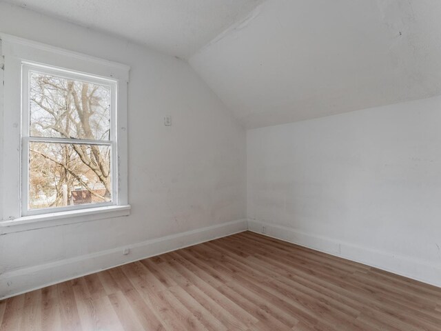 bonus room with wood-type flooring and lofted ceiling