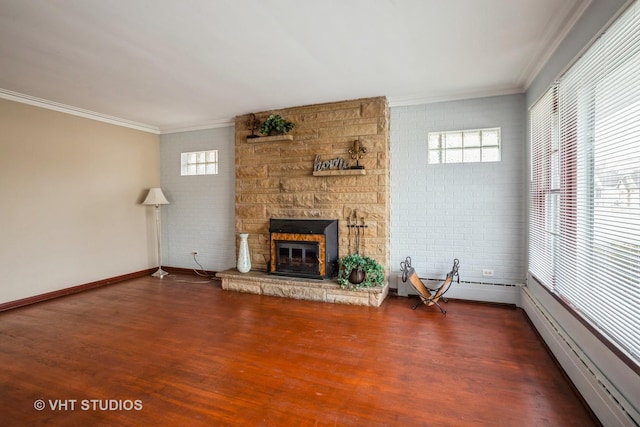 unfurnished living room featuring a fireplace, ornamental molding, baseboard heating, and brick wall