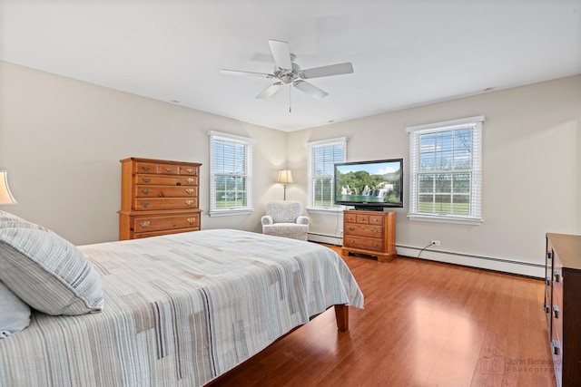 bedroom featuring a baseboard radiator, light hardwood / wood-style flooring, and ceiling fan