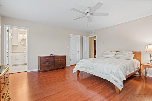 bedroom featuring ensuite bath, ceiling fan, and hardwood / wood-style flooring