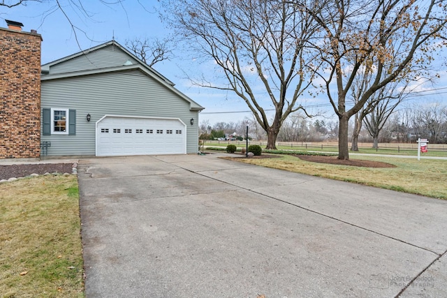 view of side of home featuring a lawn and a garage