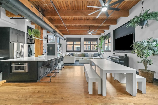 dining space featuring beamed ceiling, light hardwood / wood-style flooring, ceiling fan, and wooden ceiling