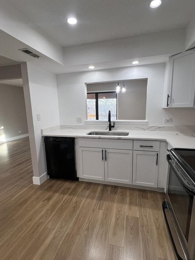 kitchen featuring black appliances, white cabinetry, sink, and light hardwood / wood-style flooring