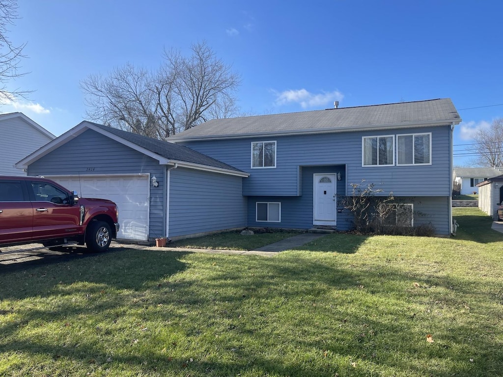 split foyer home featuring a garage and a front lawn