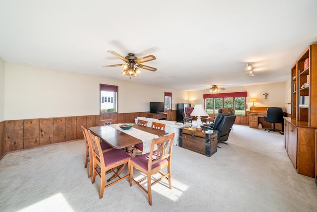 dining space featuring light carpet and ceiling fan