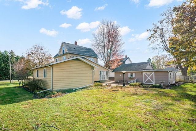 rear view of property featuring a lawn and a patio