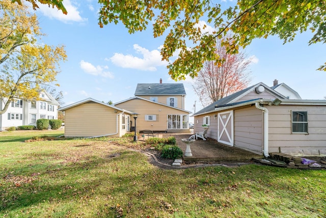 rear view of property featuring a lawn