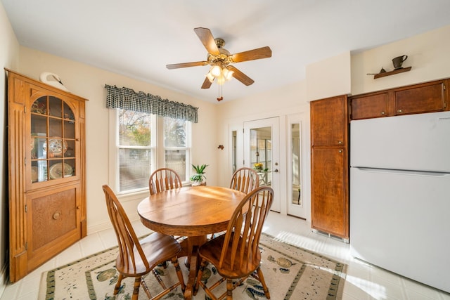 tiled dining space with ceiling fan and french doors