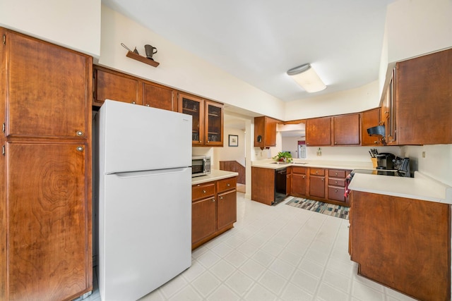 kitchen featuring dishwasher, white refrigerator, and range