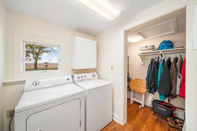 laundry room featuring separate washer and dryer and light hardwood / wood-style flooring