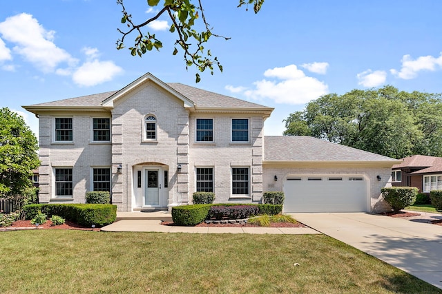 colonial home with a front lawn and a garage