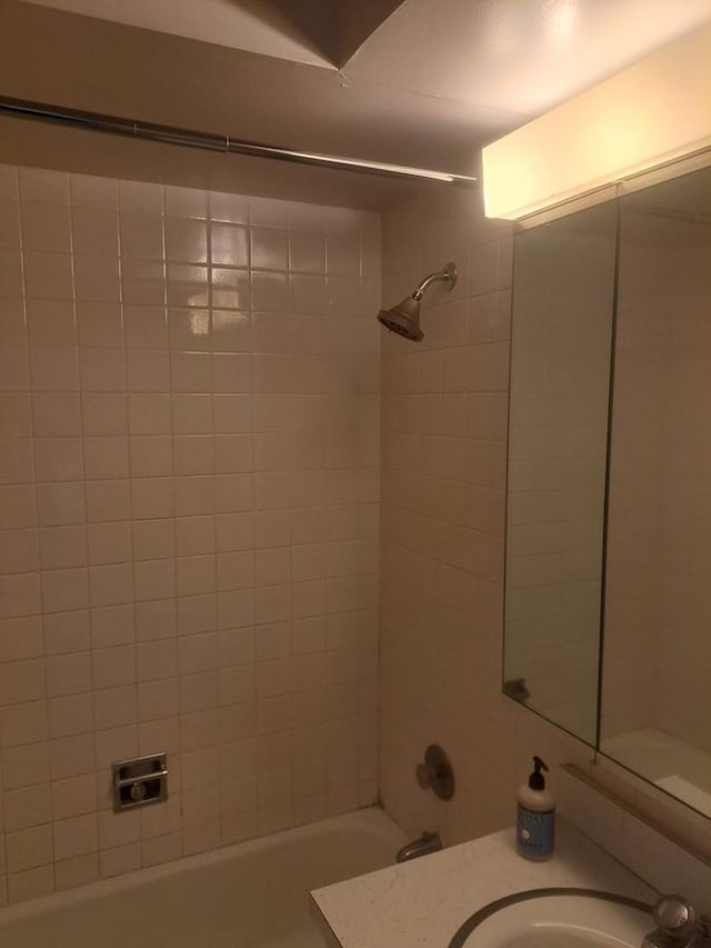 bathroom featuring vanity and tiled shower / bath