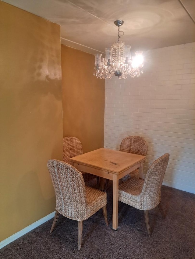 dining space featuring carpet, brick wall, and an inviting chandelier