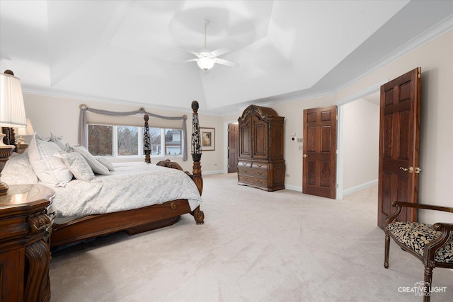 carpeted bedroom with ceiling fan, a tray ceiling, and ornamental molding