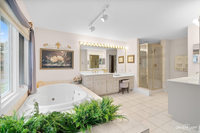 bathroom with a healthy amount of sunlight, tile patterned floors, plus walk in shower, and vanity