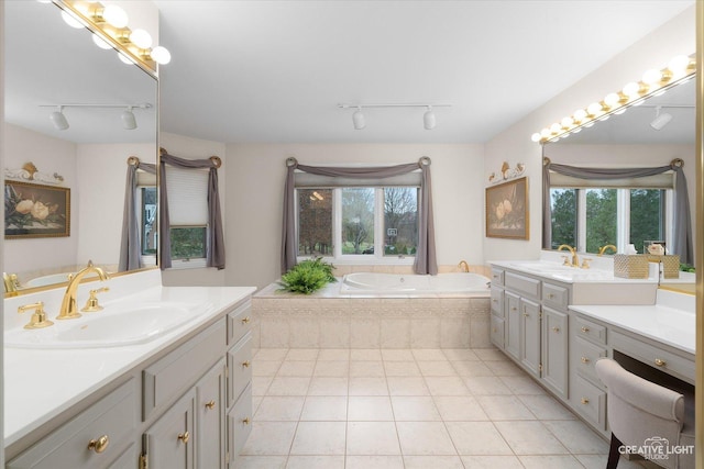 bathroom featuring a healthy amount of sunlight, vanity, tile patterned floors, and a relaxing tiled tub