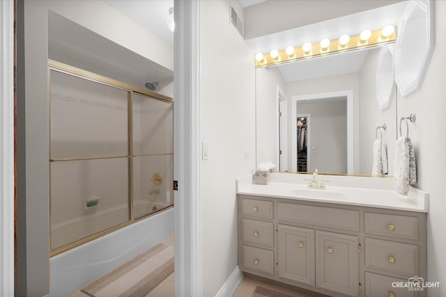 bathroom featuring enclosed tub / shower combo and vanity