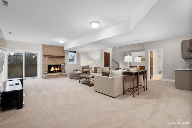 carpeted living room with sink and a stone fireplace