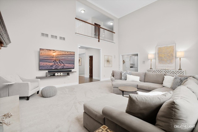 carpeted living room with a high ceiling