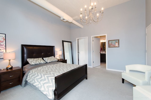 carpeted bedroom featuring a notable chandelier, a high ceiling, and connected bathroom