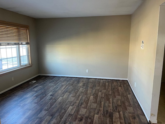 unfurnished room with dark wood-type flooring