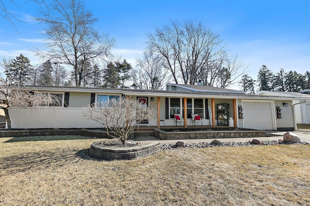 view of front of home featuring a garage, a porch, and a front yard