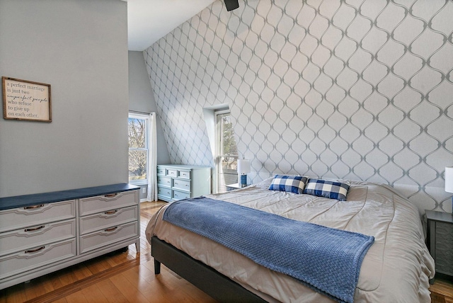 bedroom with hardwood / wood-style floors and a high ceiling