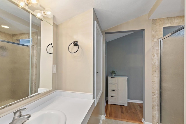 bathroom with vanity, lofted ceiling, hardwood / wood-style floors, and a shower with shower door